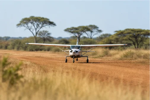 Light aircraft flying above East African savannah